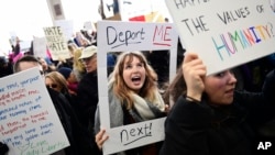 Madison Gray, a Temple University student, holds up her sign during a protest against President Donald Trump's executive order banning travel to the U.S. by citizens of Iraq, Syria, Iran, Sudan, Libya, Somalia or Yemen, Sunday, Jan. 29, 2017, at Philadelp