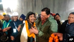 2023年11月28日，印度北阿坎德邦首席部长普什卡尔·辛格·达米在迎接一名被救出的工人。（美联社照片）