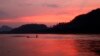 In this March 4, 2011, file photo, men ride in a boat across the Mekong River in Luang Prabang, Laos. It is officially described as the best-preserved city in Southeast Asia, a bygone seat of kings tucked into a remote river valley of Laos. Luang Prabang weaves a never-never land spell on many a visitor with its tapestry of French colonial villas and Buddhist temples draped in a languid atmosphere. (AP Photo/Jacquelyn Martin, File)