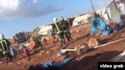 This screenshot from a video posted by the 'White Helmet' Syrian civil defense group shows the aftermath of what opposition groups say was an airstrike at the Kamouna refugee camp.