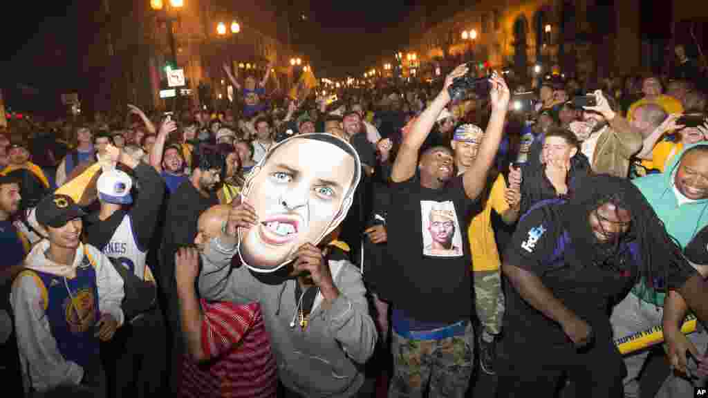 Une foule de supporteurs de Golden State Warriors jubile au centre d&#39;Oakland, en Californie, après la victoire de leur équipe 105-97 contre les Cavaliers de Cleveland 105-97 lors du 6e match des finales de la NBA, mardi 16 Juin, 2015