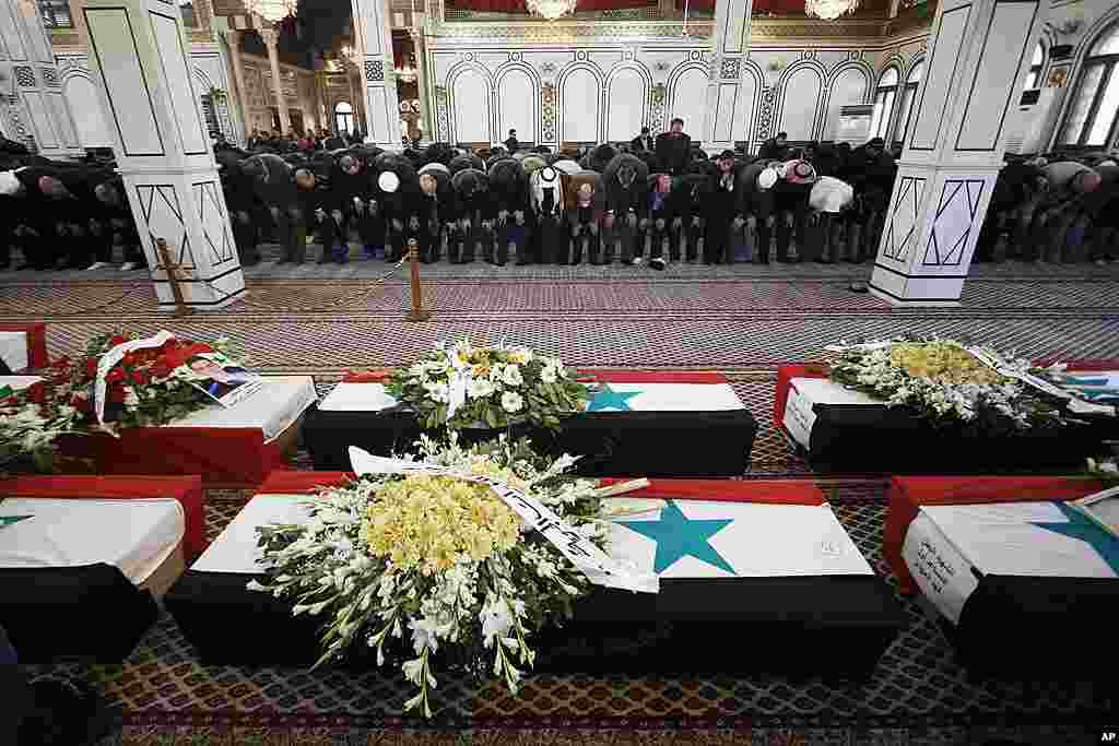 Men bow in prayer at a funeral of the victims of a bombing in Damascus, Syria. (AP)