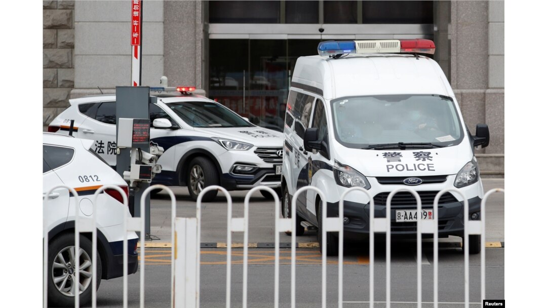 FILE - An escorted police van believed to be carrying Huayuan Real Estate Group former chairman Ren Zhiqiang leaves Beijing No. 2 Intermediate People's Court, where Ren faces corruption trial, in Beijing, Sept. 11, 2020.