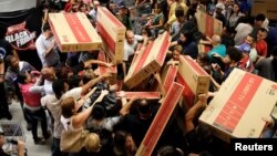 Shoppers reach for television sets as they compete to purchase retail items on Black Friday at a store in Sao Paulo, Brazil, Nov. 24, 2016. 