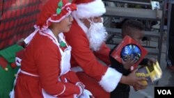 Santa and Mrs. Claus distributed gifts to the kids at the Corps' annual holiday party. (M. O'Sullivan/VOA)