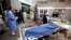 Relatives stand next to the body of a man in Lady Reading Hospital in Peshawar, March 21, 2013.