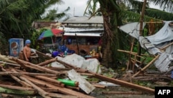 Seorang warga memperhatikan rumah yang rusak saat puncak Taifun Phanfone di Tacloban, Provinsi Leyte, Filipina, 25 December 2019. 