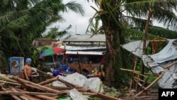 A resident looks at a house damaged at the height of Typhoon Phanfone in Tacloban, Leyte province in the central Philippines, Dec. 25, 2019.