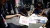 FILE - People make posters during a protest condemning the rape and murder of a trainee medic at a government-run hospital, in Kolkata, India, October 15, 2024. 