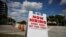 A "Now Hiring" sign advertising jobs at a hand car wash is seen along a street, as the spread of the coronavirus disease (COVID-19) continues, in Miami, Florida, May 8, 2020. 