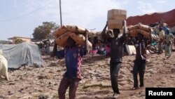 FILE - Men carry humanitarian aid in Mopti, Mali, February 4, 2013.