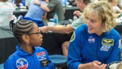 in this July 13, 2018 file photo, NASA astronaut Dottie Metcalf-Lindenburger talks with Space Camp camper Bria Jackson, of Atlanta, before giving a speech at the U.S. Space & Rocket Center in Huntsville, Ala. Space Camp.