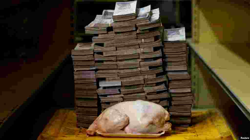 Un pollo de 2,4 kg junto a 14.600.000 de bolívares, equivalente a 2,22 dólares, en un mini mercado en Caracas, Venezuela, el 16 de agosto de 2018.