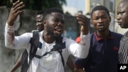 FILE - Alister, a protester who says his brother Emeka died from a stray bullet from the army, reacts while speaking to Associated Press near Lekki Toll Gate in Lagos, Nigeria, Oct. 20, 2020.