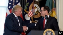 FILE - President Trump shakes hands with Treasury Secretary Mnuchin at the Treasury Department, April 21, 2017, where the president signed an executive order to review tax regulations set last year by his predecessor, as well as memos to potentially reconsider major elements of the 2010 Dodd-Frank financial reforms passed in the wake of the Great Recession.