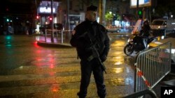 FILE - A police officer stands guard near the Bataclan concert hall in Paris, France, Nov. 12, 2016. The hall was among the sites attacked by terrorists in Paris on Nov. 13, 2015. The attacks left 130 people dead.