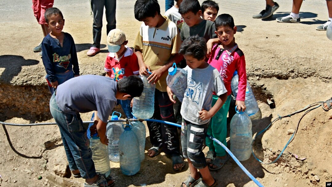 Anak-anak pengungsi Suriah mengisi botol air minum di sebuah kamp pengungsi di Lebanon timur (foto: dok). 