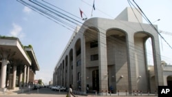 A pedestrian walks near the Bank of the Republic of Haiti, right, in Port-au-Prince, Haiti, March 21, 2019.