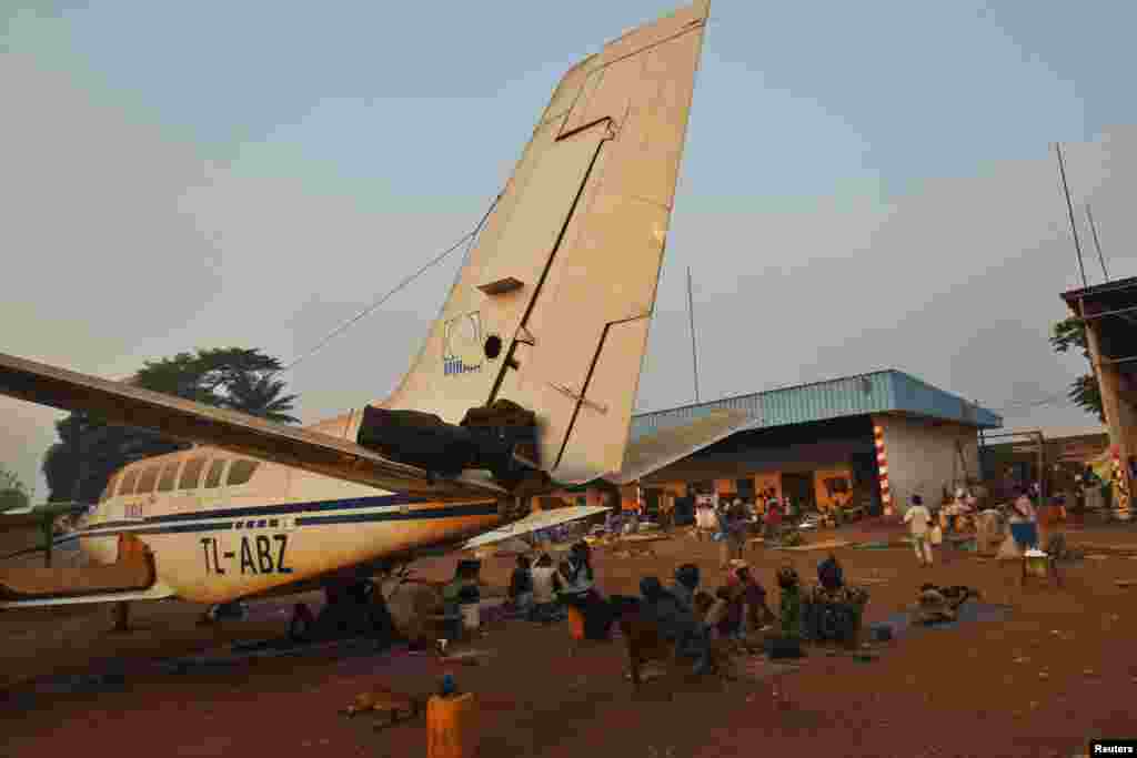 Sebuah keluarga duduk dekat pesawat di kamp pengungsi di bandar udara internasional M&#39;Poko di Bangui (20/2). (Reuters/Luc Gnago)