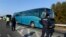 Greek police officers direct buses carrying hundreds of migrants, who were stranded on the Greek-Macedonian border and blocked rail traffic, after a police operation near the village of Idomeni, Greece, Dec. 9, 2015. 