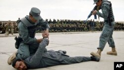 Afghan policemen demonstrate their skills during a graduation ceremony at a police training center in Herat province, March 10, 2011. 