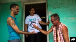 Danilo Maldonado (izq.) saluda a un amigo delante de la vivienda de la casa de su madre María Victoria Machado, en La Habana, en esta foto de octubre de 2015 (AP).