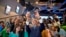Secretary of State John Kerry takes a selfie with a group of students before delivering a speech on climate change in Jakarta, Indonesia, Feb. 16, 2017.