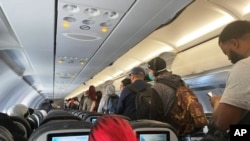 FILE - In this Monday, April 27, 2020, file photo, provided by Vince Warburton, passengers get off an American Airlines flight after they landed at Los Angeles International Airport in Los Angeles.