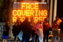 A sign encourages visitors to wear face masks amid the COVID-19 pandemic Feb. 19, 2021, in Santa Monica, Calif.