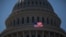 FILE - An American flag flies in front of the dome of the U.S. Capitol, July 26, 2011.