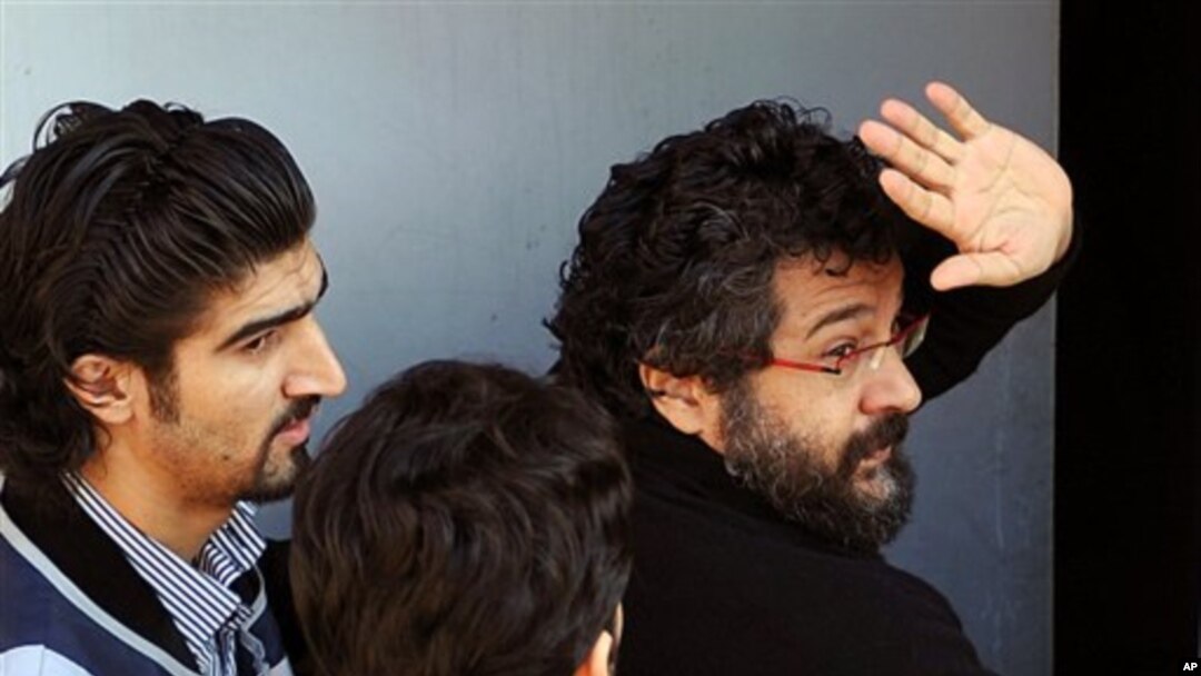 Police officers escort journalist Soner Yalcin, right, during a medical check in Istanbul, Turkey, Feburary 17, 2011