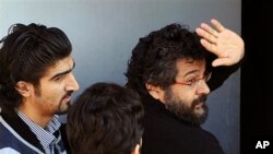 Police officers escort journalist Soner Yalcin, right, during a medical check in Istanbul, Turkey, Feburary 17, 2011