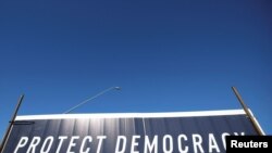 A campaign sign with the slogan "Protect Democracy" stands in Tuscon