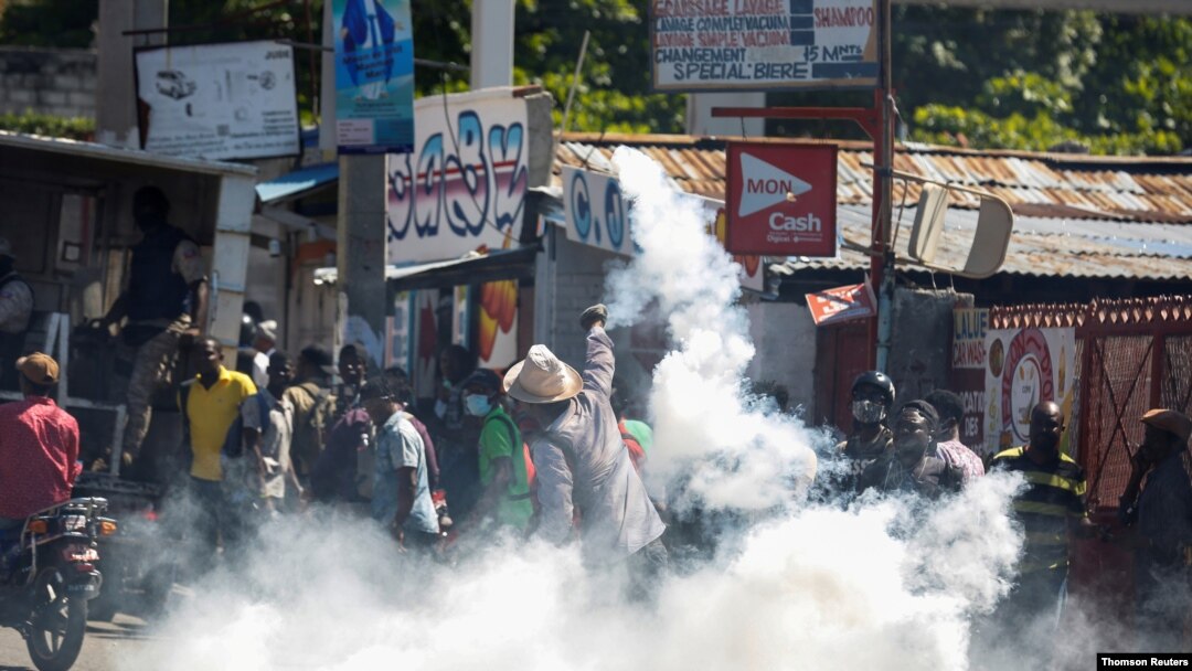 Un hombre arroja un bote de gas lacrimógeno a la policía durante una protesta contra el presidente de Haití, Jovenel Moise, en Puerto Príncipe, el 11 de febrero de 2021.