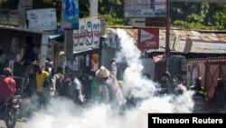Un hombre arroja un bote de gas lacrimógeno a la policía durante una protesta contra el presidente de Haití, Jovenel Moise, en Puerto Príncipe, el 11 de febrero de 2021.