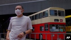 Occupy Central leader Benny Tai stands in front of a vintage double-deck bus used as a polling center for voting in Hong Kong Saturday, July 11, 2020, in an unofficial “primary” for pro-democracy candidates ahead of legislative elections in September.