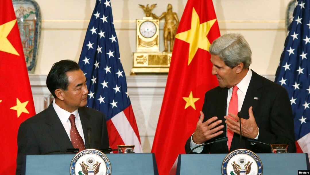 Menlu China Wang Yi (kiri) mendengarkan pernyataan Menlu AS John Kerry sebelum perundingan bilateral keduanya di Kemenlu AS, Washington DC, 19/9/2013.