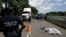 A Central American migrant, who fell from the back of a moving vehicle and died, lies on a highway covered by a sheet outside of Tapachula, Mexico, Oct. 22, 2018.