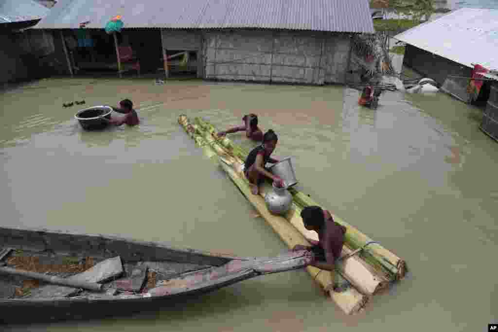 인도 아삼주 모리가온의 마을이 계절성 폭우의 여파로 침수된 가운데 주민들이 임시로 만든 뗏목을 타고 대피하고 있다. 