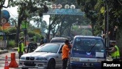 Ilustrasi: Petugas memeriksa mobil di pos pemeriksaan di Tasikmalaya, Provinsi Jawa Barat, pada hari pertama larangan mudik menjelang lebaran di tengah pandemi COVID-19, 6 Mei 2021. (Antara Foto / Adeng Bustomi / via Reuters.)