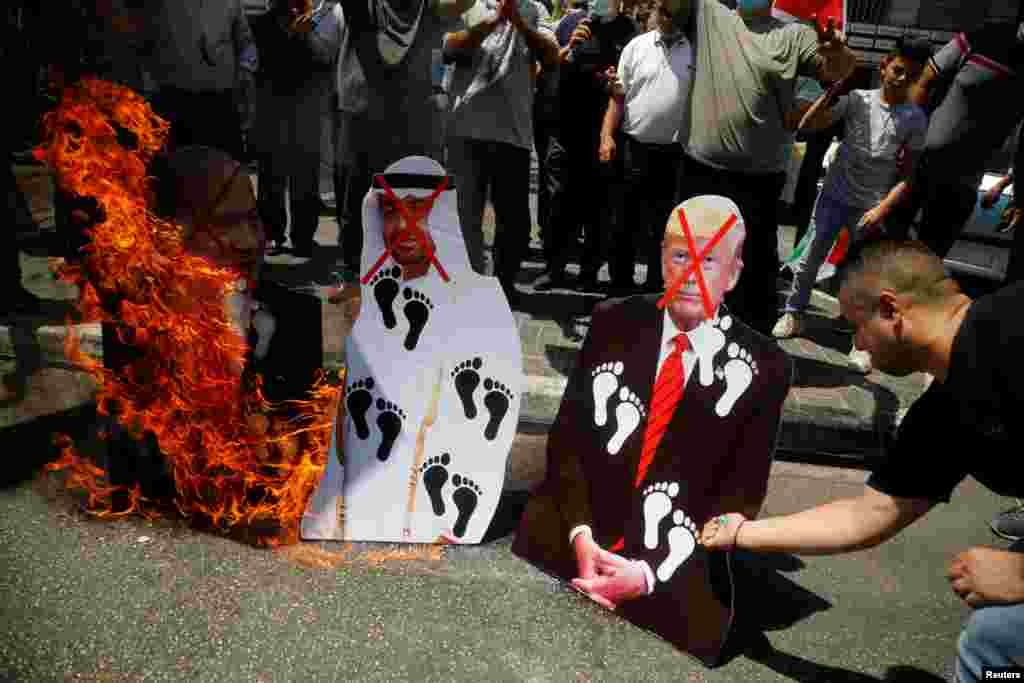 Palestinians burn cutouts depicting U.S. President Donald Trump and Abu Dhabi Crown Prince Mohammed bin Zayed al-Nahyan and Israeli Prime Minister Benjamin Netanyahu during a protest in Nablus in the Israeli-occupied West Bank.