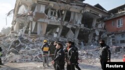 FILE: Turkish police officers walk past by a damaged building as they patrol, in the aftermath of a deadly earthquake in Hatay, Turkey February 11, 2023