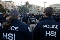 Federal agents gather at an apartment complex, March 3, 2015, in Irvine, Calif. Shortly after sunrise, agents swarmed the complex where authorities say a birth tourism business charged pregnant women $50,000.