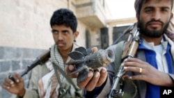 A Yemeni armed tribe member loyal to anti-government protesters displays remains of a projectile in the Al Nahda neighborhood of Sanaa September 24, 2011.