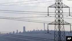 FILE - Electricity pylons cross the skyline of Johannesburg city, South Africa.