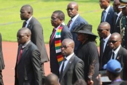 Zimbabwean President Emmerson Mnangagwa pays his respects to former Zimbabwean leader Robert Mugabe, at the National Sports stadium during a funeral ceremony in Harare, Sept, 14, 2019.