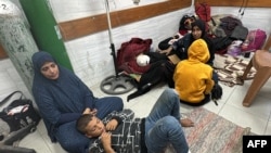 FILE - Women and children wait for medical attention as they sit on the floor of the trauma ward in the Kamal Adwan Hospital in Beit Lahia the northern Gaza Strip, Oct. 24, 2024.