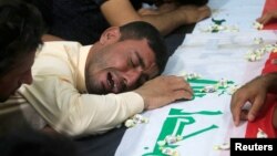 A man mourns at the funeral of the security men who were kidnapped and killed by Islamic State militants, in Kerbala, Iraq, June 28, 2018. 