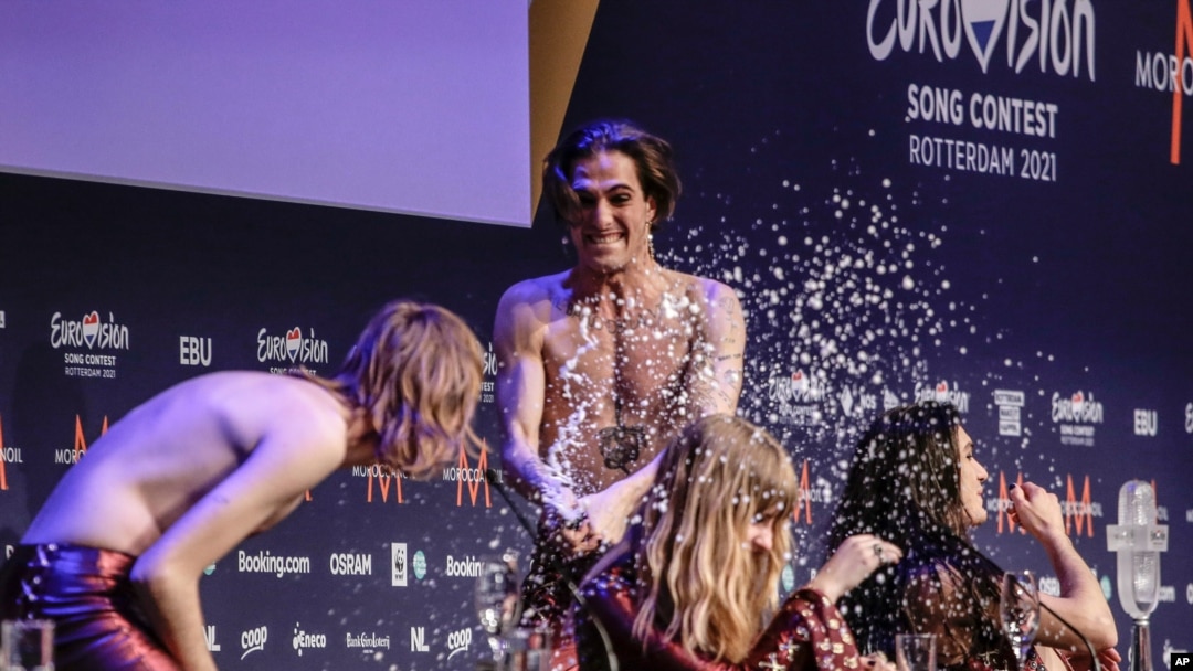 Damiano David, al centro, rocía de champaña a Thomas Taggi, Victoria de Angelisa y Ethan Torchio, en conferencia de prensa al regresar a Roma.