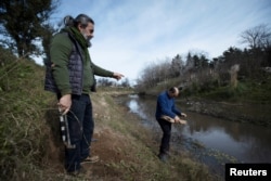 Ahli paleontologi Argentina Martin de los Reyes (48) dan lulusan antropologi biologi Argentina Mariano Del Papa (53) di tepi Sungai Reconquista di Merlo, Buenos Aires, Argentina tempat ditemukannya fosil Glyptodon, 3 Juli 2024. (Mariana Nedelcu/REUTERS)